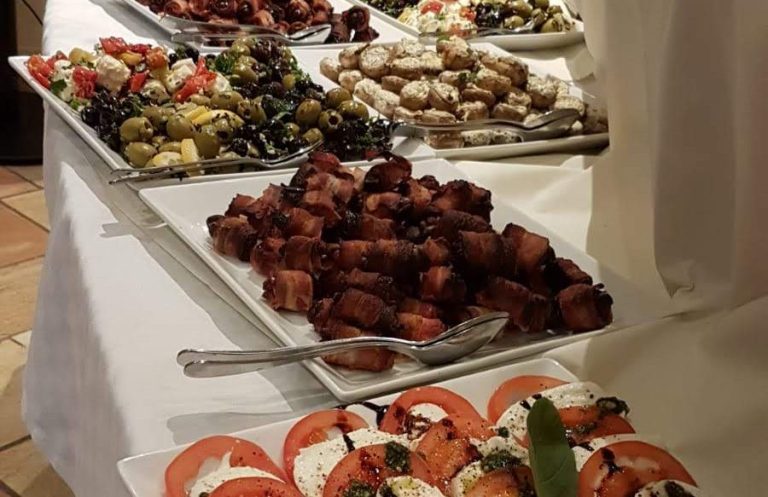 Ein Buffet mit verschiedenen Platten, darunter Fleisch, Gemüse und Salate.