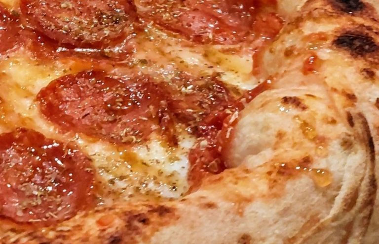 Pizza mit knusprigem Rand, belegt scharfer Salami und Chili-Honig.